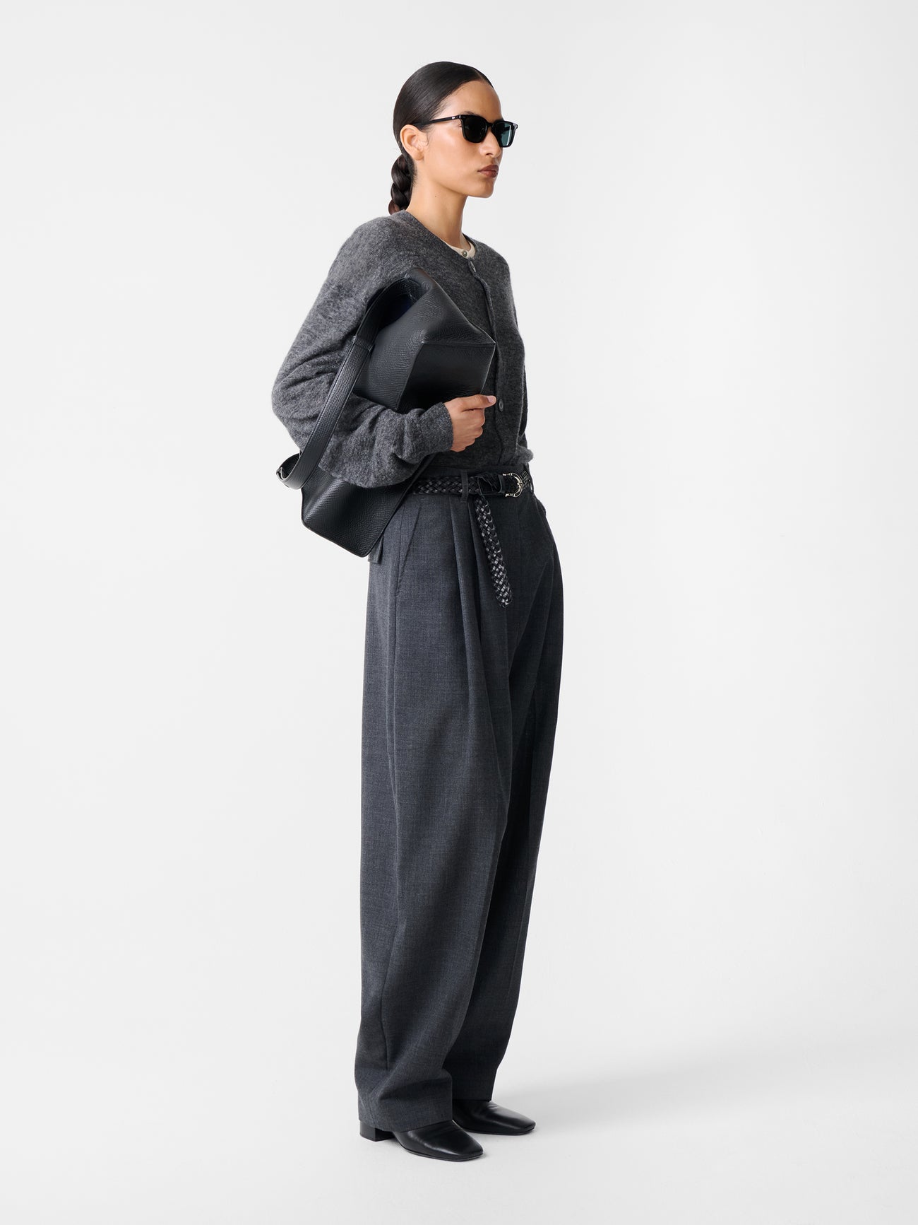 Model in Studio Nicholson Acuna Wool Pant shown at an angle, emphasizing pleated front and generous cut.