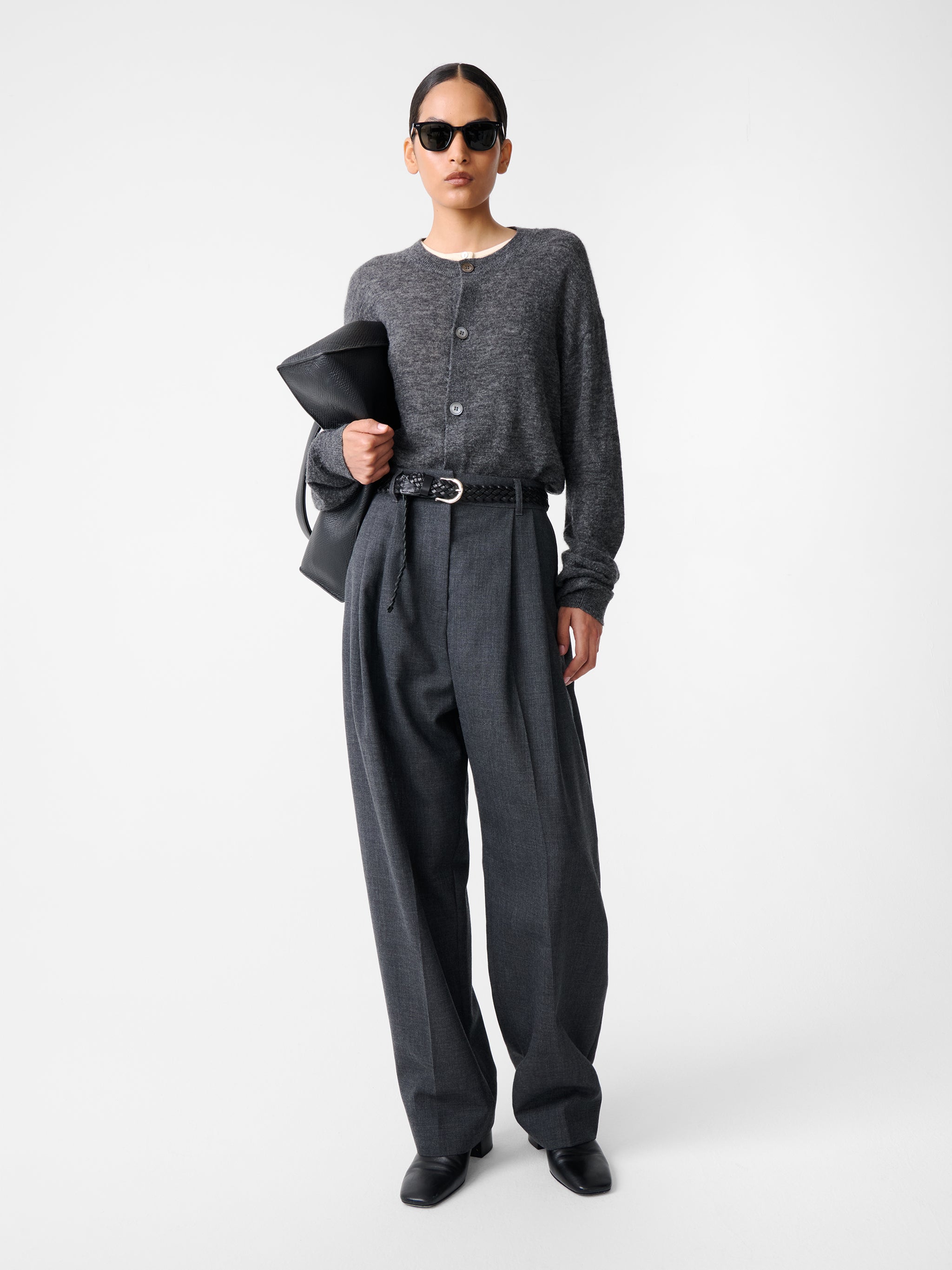 Model wearing Studio Nicholson Acuna Wool Pant in slate melange, styled with a dark top and sunglasses, showing high-rise wide-leg silhouette.