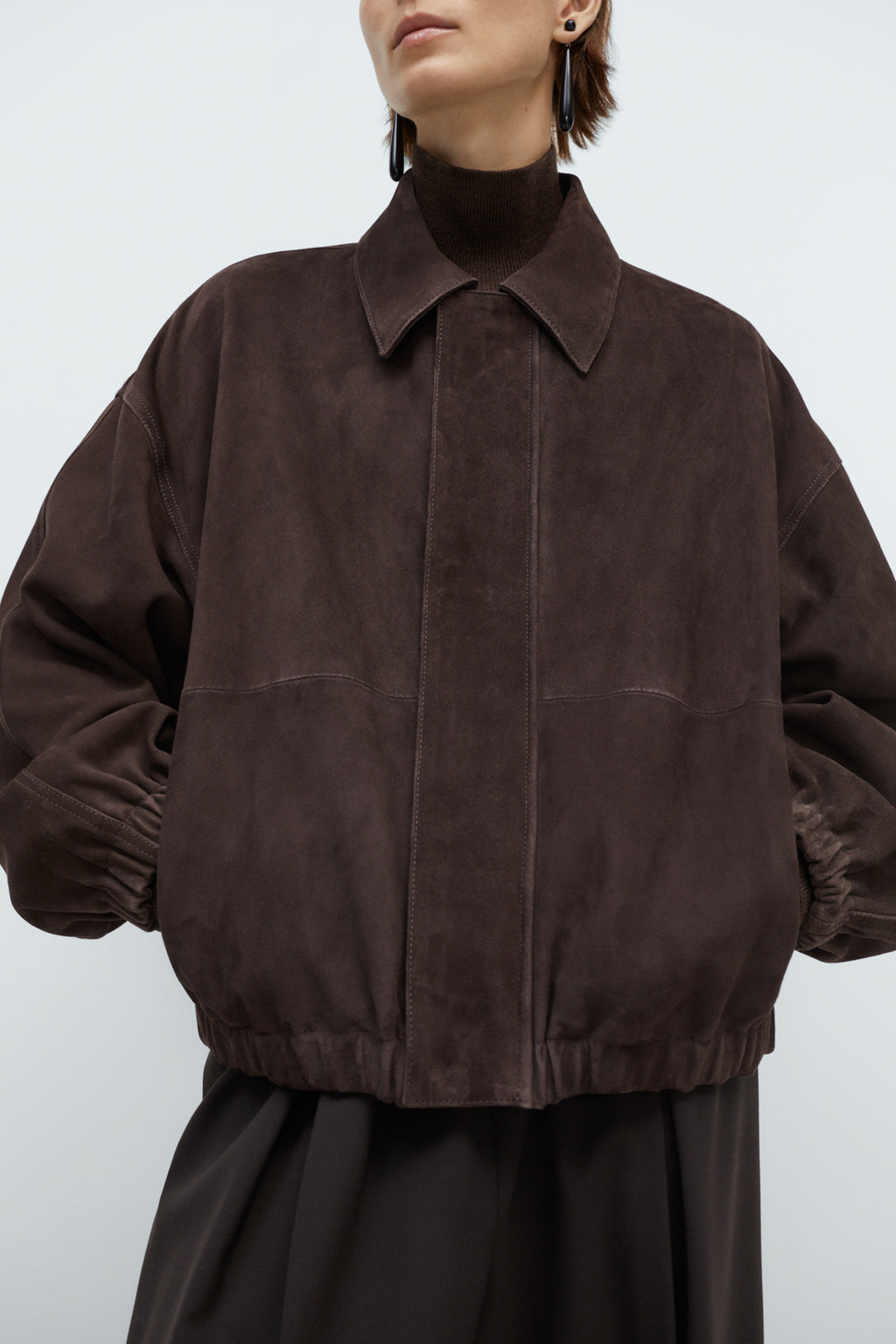 Brown suede jacket worn by a person on a white background