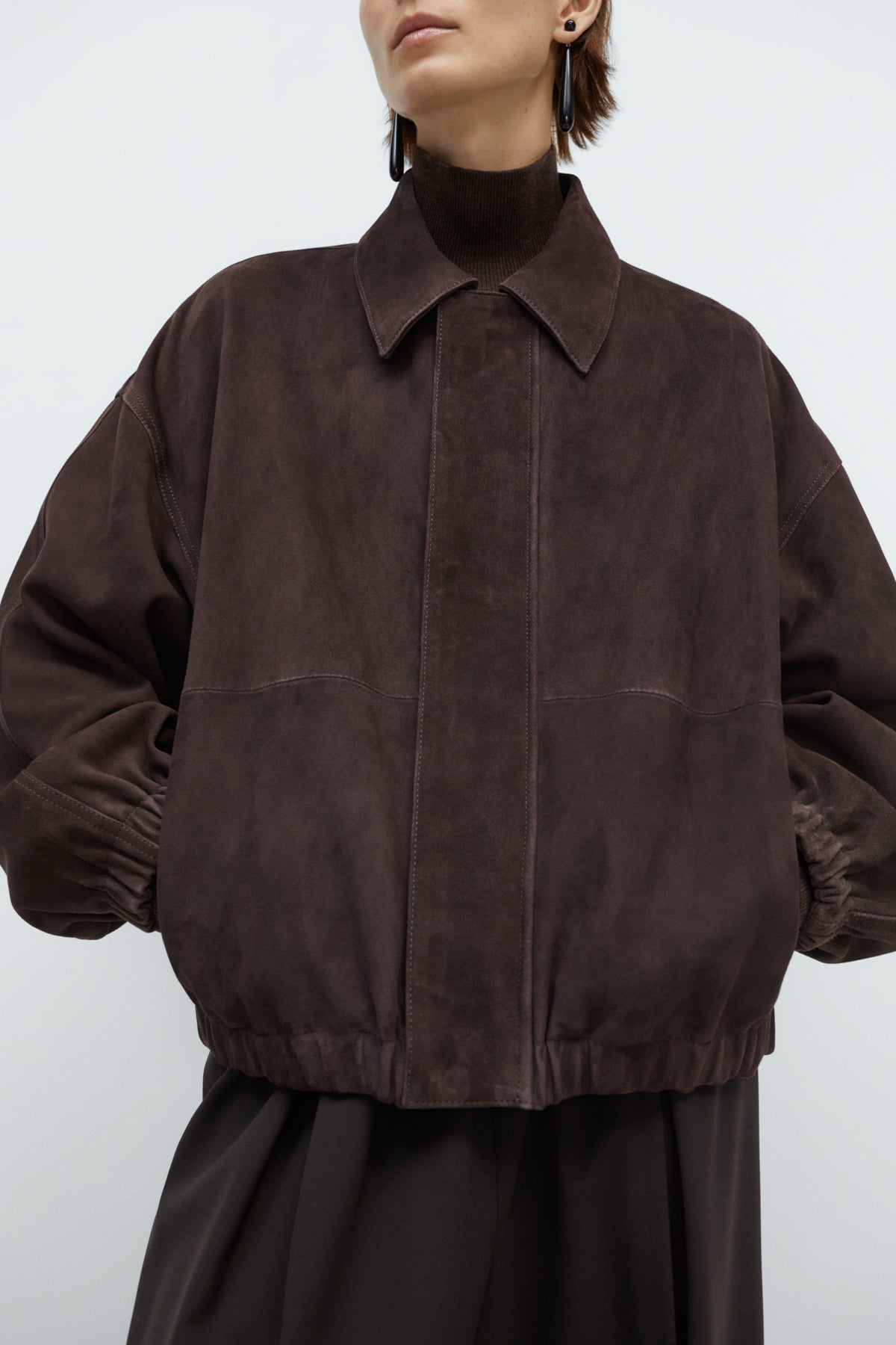 Brown suede jacket worn by a person on a white background