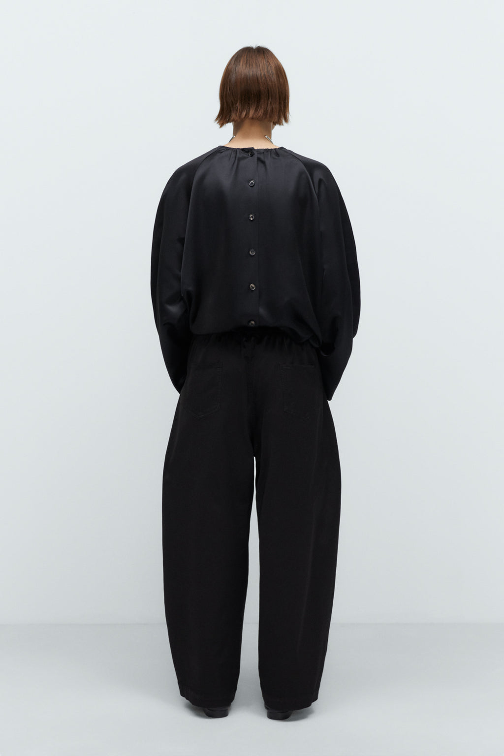 Person wearing a black outfit on a white background