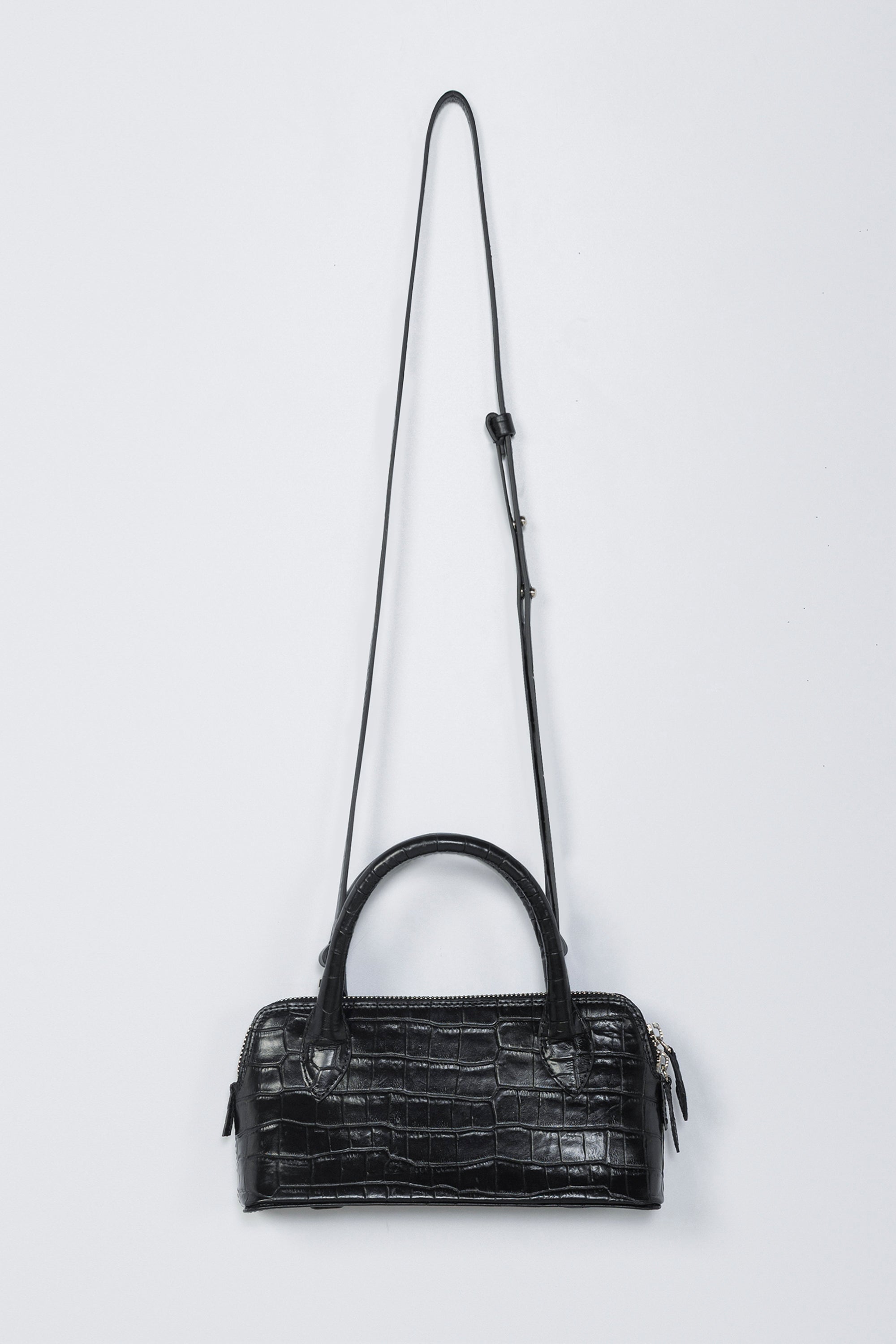 Black handbag with a strap on a white background