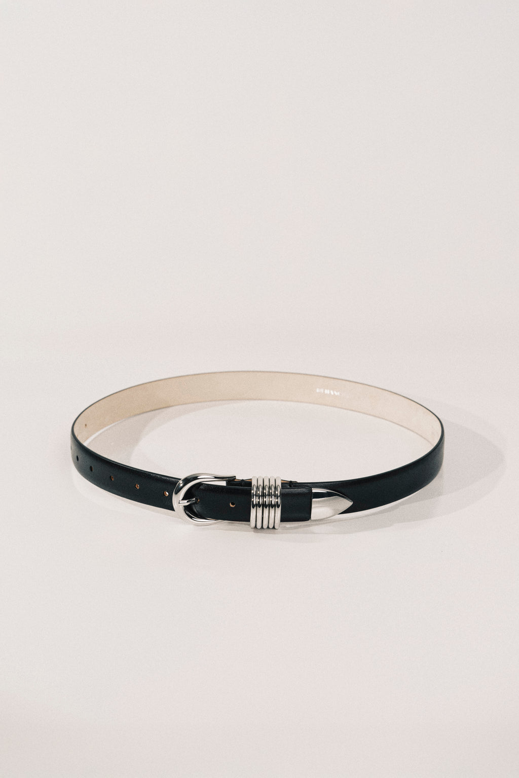 Black belt with a silver buckle on a light gray background