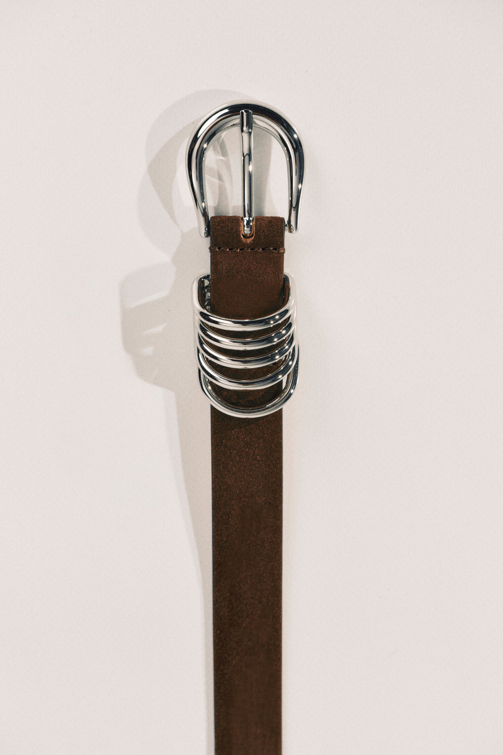 Brown belt with a silver buckle on a white background