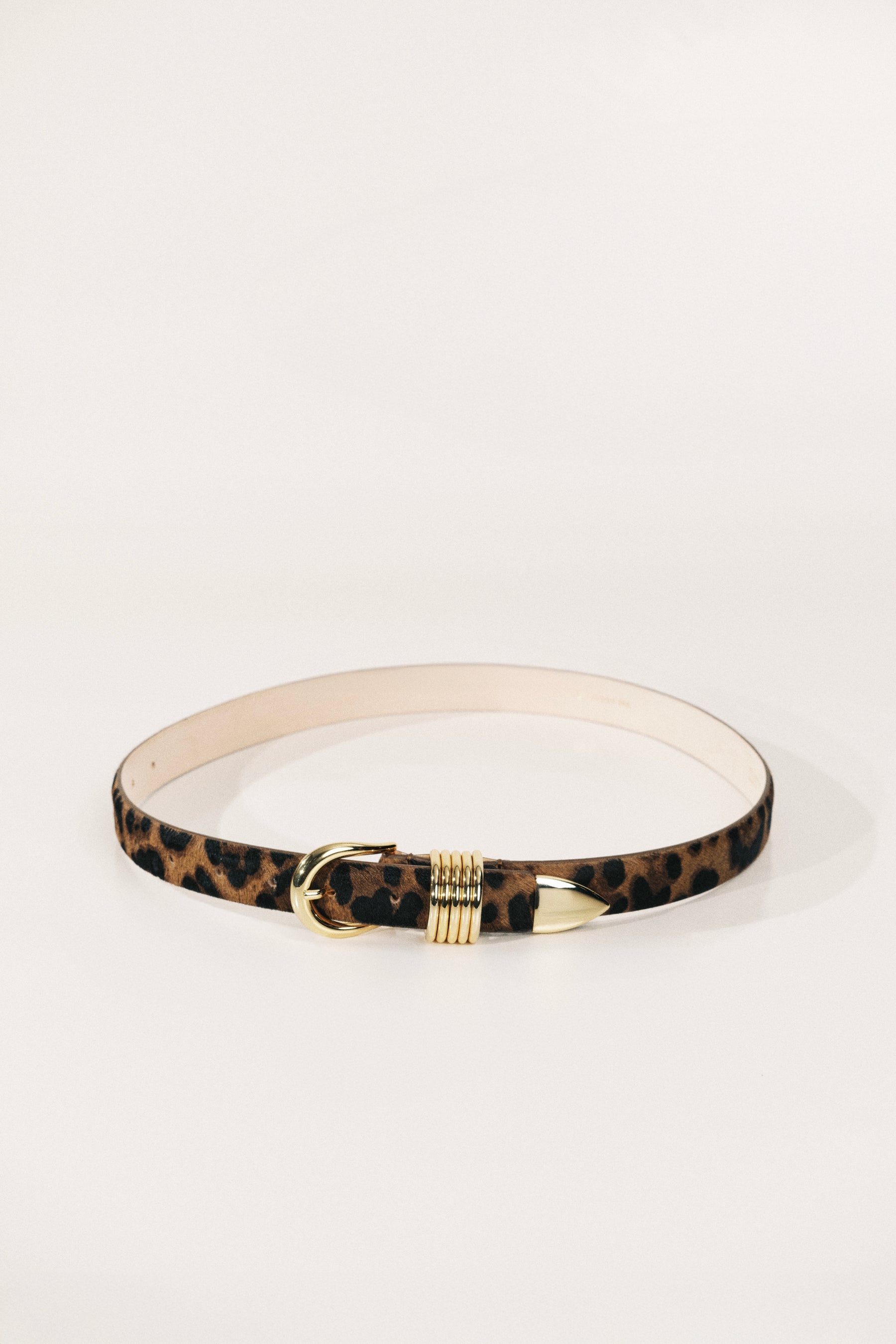 Leopard print belt with gold buckle on a white background