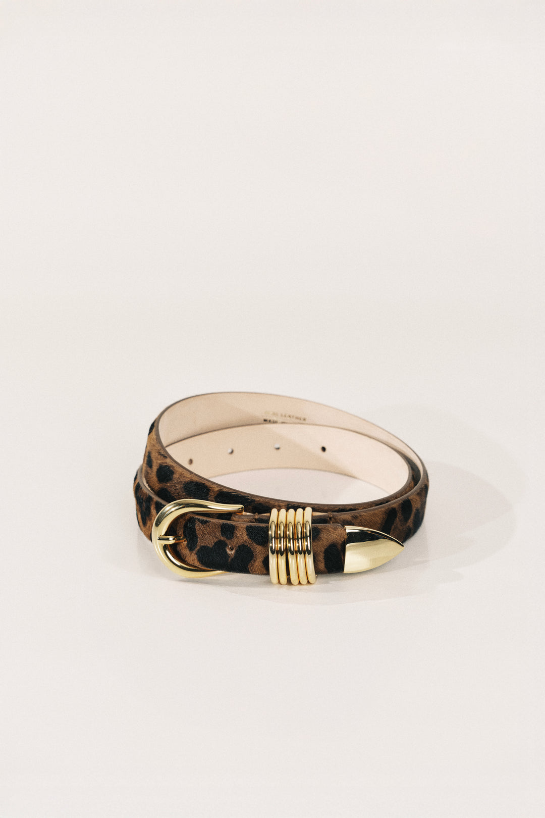 Belt with leopard print strap and gold buckle on a white background