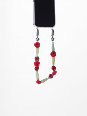 Phone lanyard with floral design attached to a phone on a white background