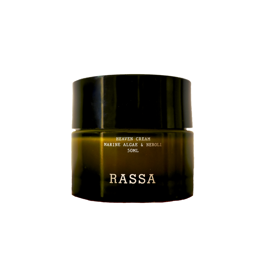 A jar of Rassa Botanicals Heaven Cream with marine algae & neroli. The jar is dark colored with a simple, elegant design.