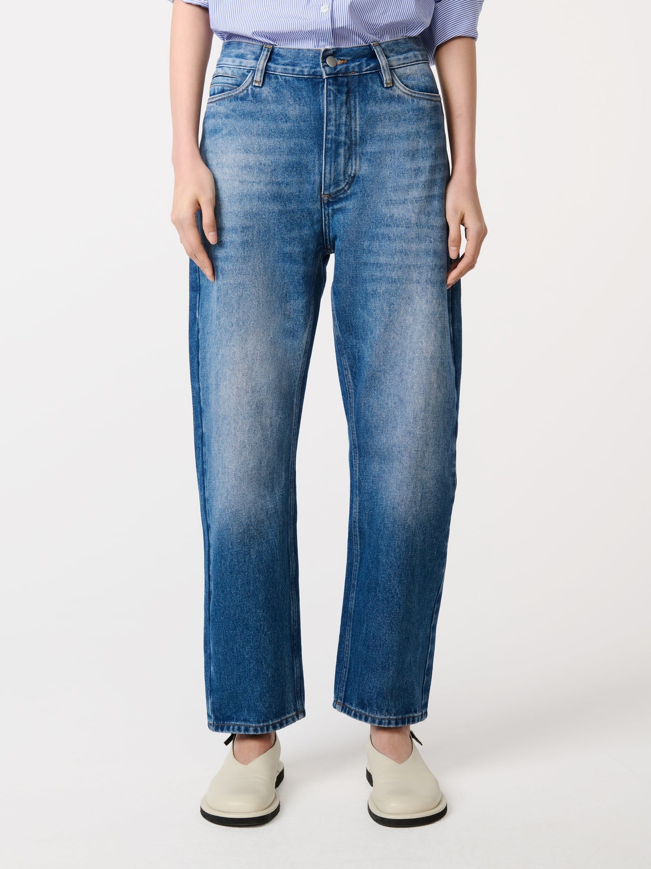 Person wearing blue jeans on a white background