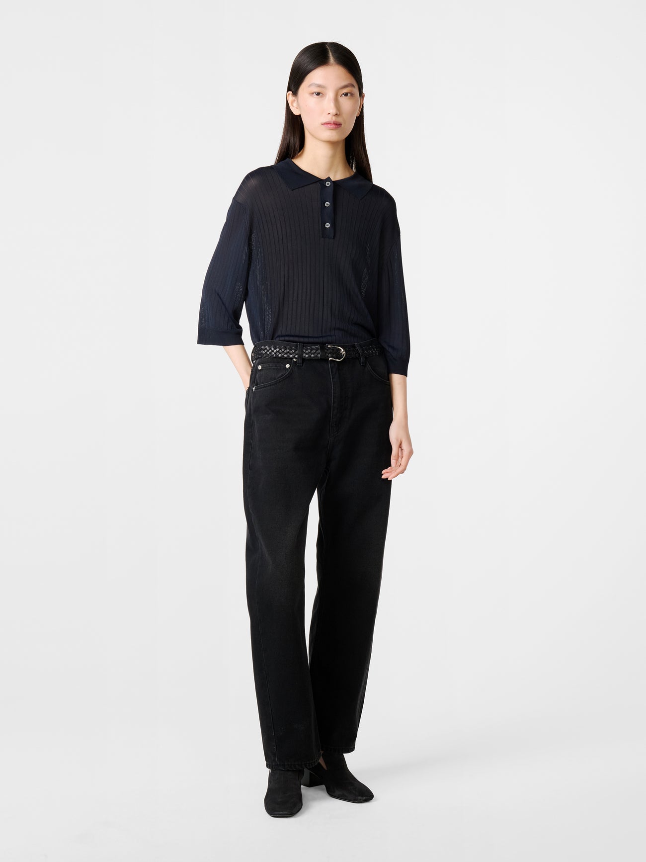 Model wearing Studio Nicholson Denjo Denim Pant in Washed Black on white background.