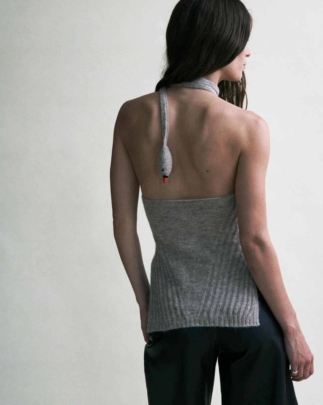 Woman wearing gray halter swan tunic from the back.