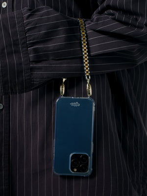 Blue phone case with gold chain held by a person wearing a black pinstripe shirt.