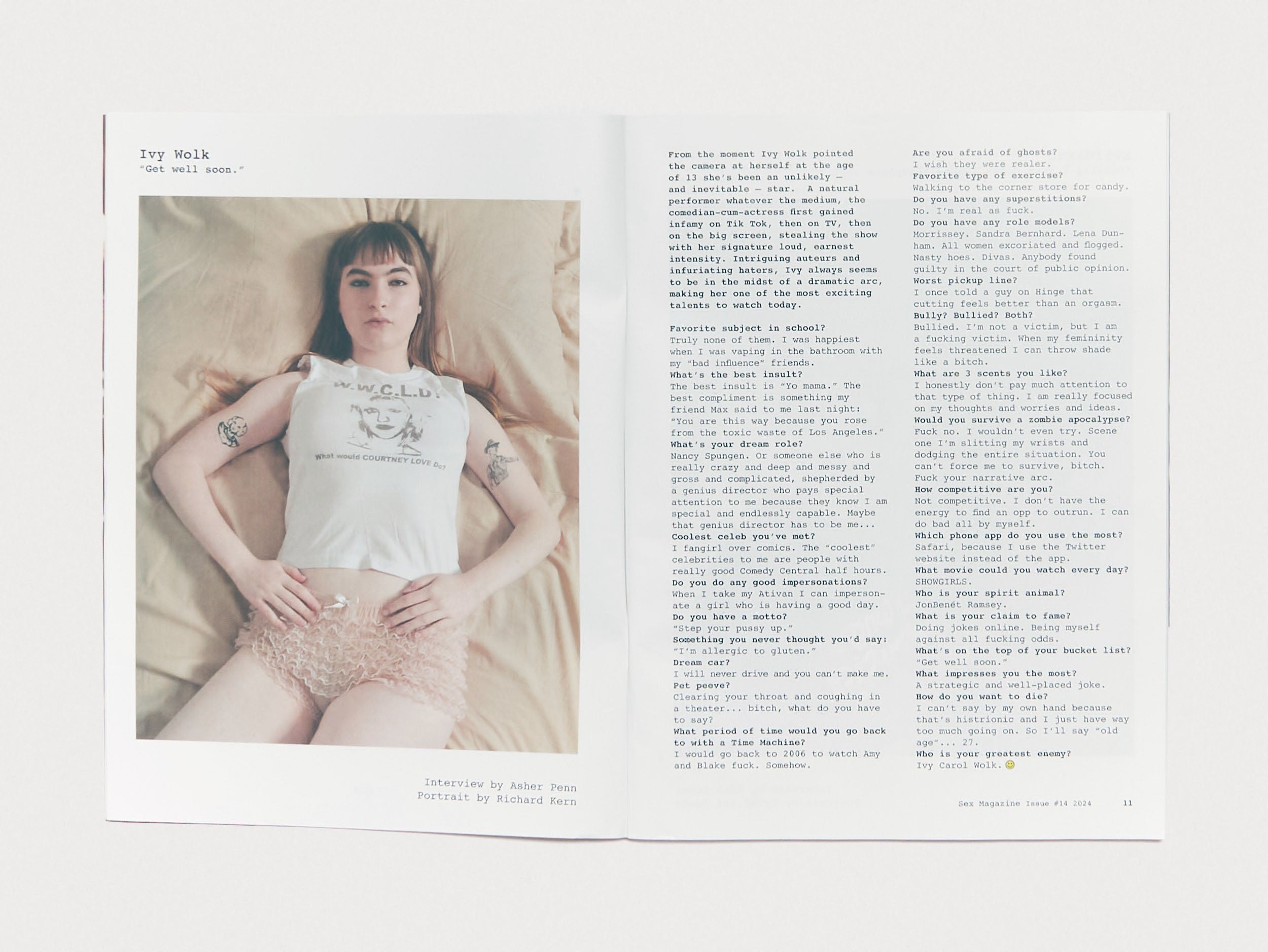 Portrait of Ivy Wolk lying on a bed, wearing a white tank and pink shorts, featured in Sex Magazine Issue 14. Text and interview layout beside the image.