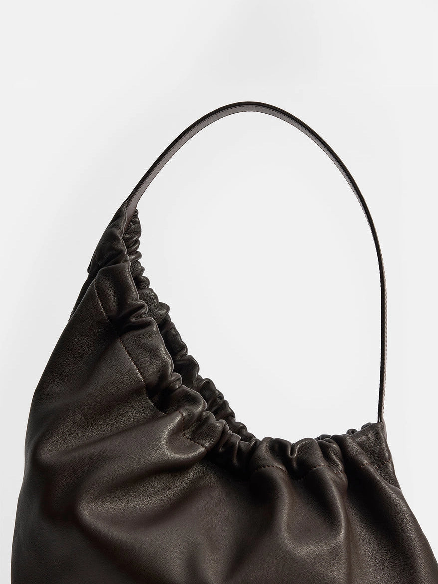 Aesther Ekme Demi Lune Cloud in tabacco calfskin with an asymmetrical shape, ruched opening and long shoulder strap.