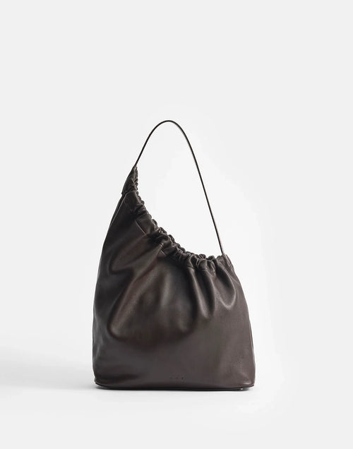 Aesther Ekme Demi Lune Cloud in tabacco calfskin with an asymmetrical shape, ruched opening and long shoulder strap.