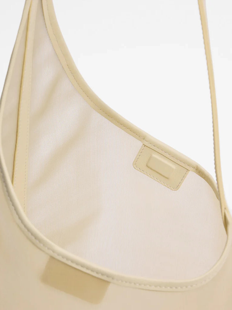 Beige handbag with a visible brand label on a white background