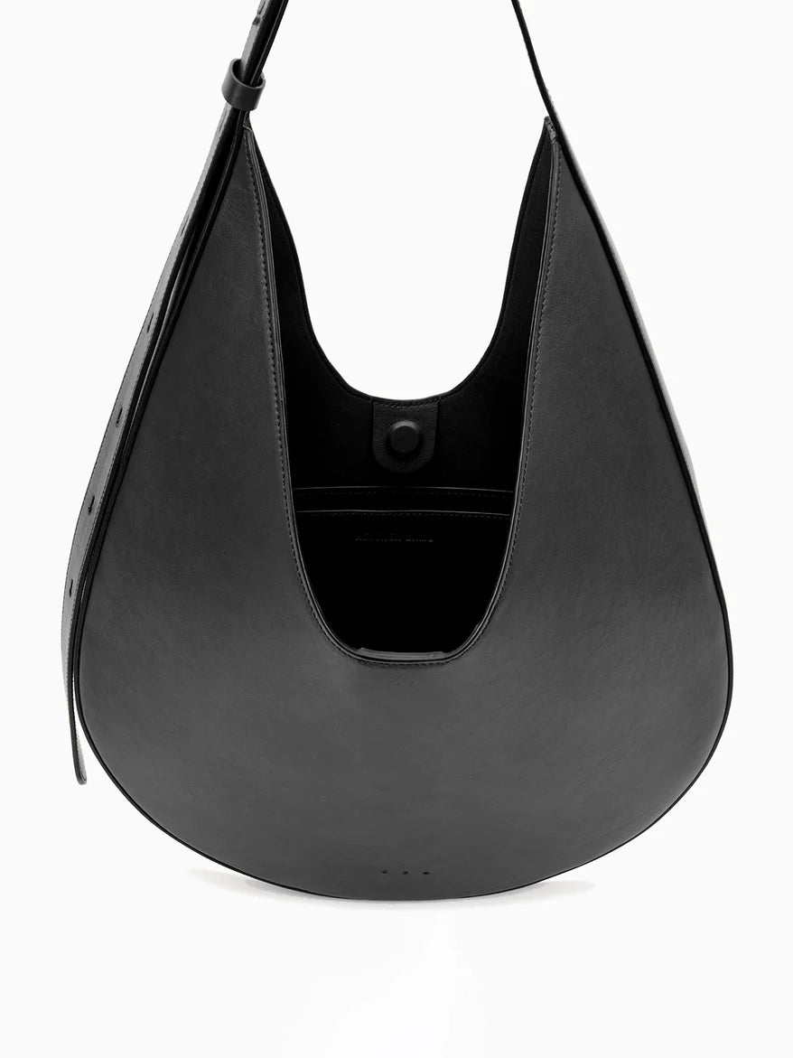 Aesther Ekme Hobo in black smooth calfskin with a sculptural curved silhouette and adjustable shoulder strap.