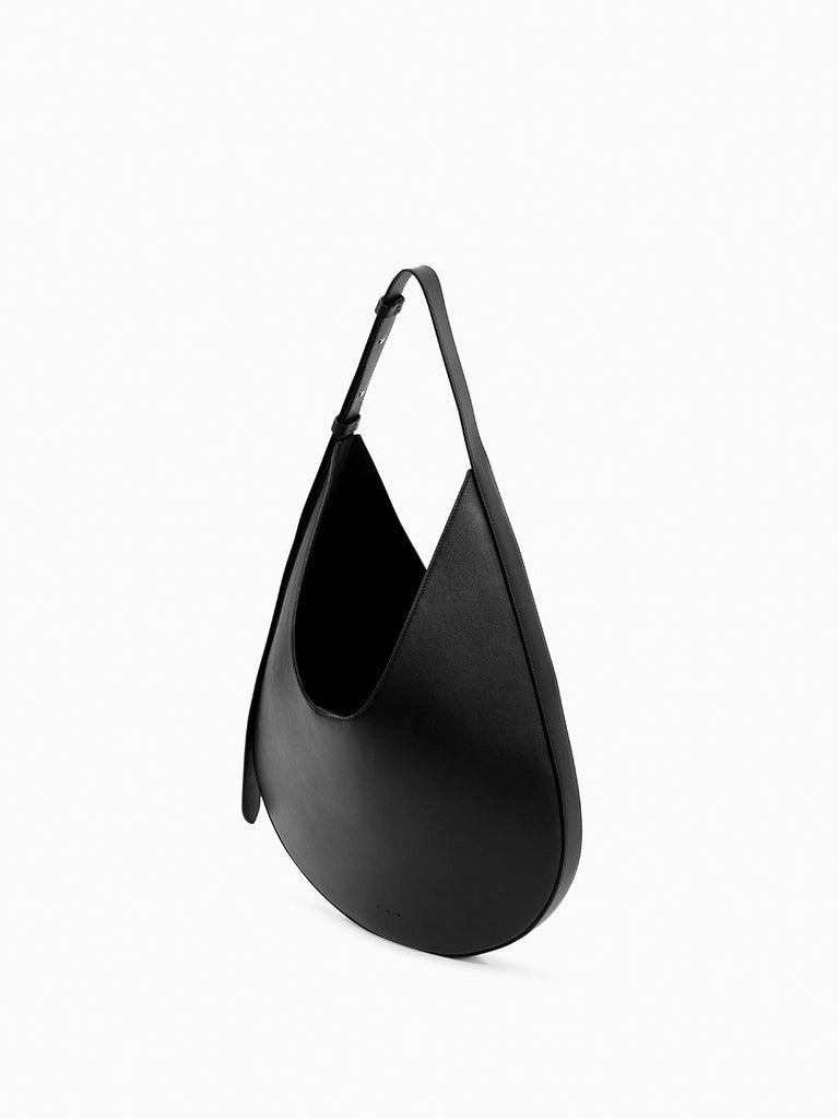 Aesther Ekme Hobo in black smooth calfskin with a sculptural curved silhouette and adjustable shoulder strap.