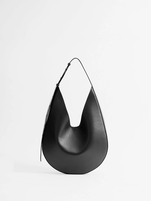 Aesther Ekme Hobo in black smooth calfskin with a sculptural curved silhouette and adjustable shoulder strap.