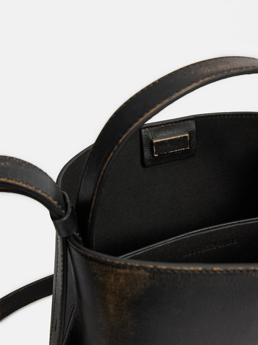 Aesther Ekme Mini Sac in vintage black calfskin with a structured silhouette, top handle and adjustable crossbody strap.