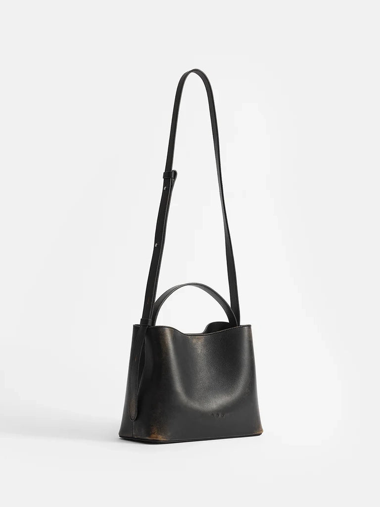Aesther Ekme Mini Sac in vintage black calfskin with a structured silhouette, top handle and adjustable crossbody strap.