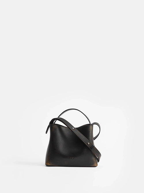 Aesther Ekme Mini Sac in vintage black calfskin with a structured silhouette, top handle and adjustable crossbody strap.
