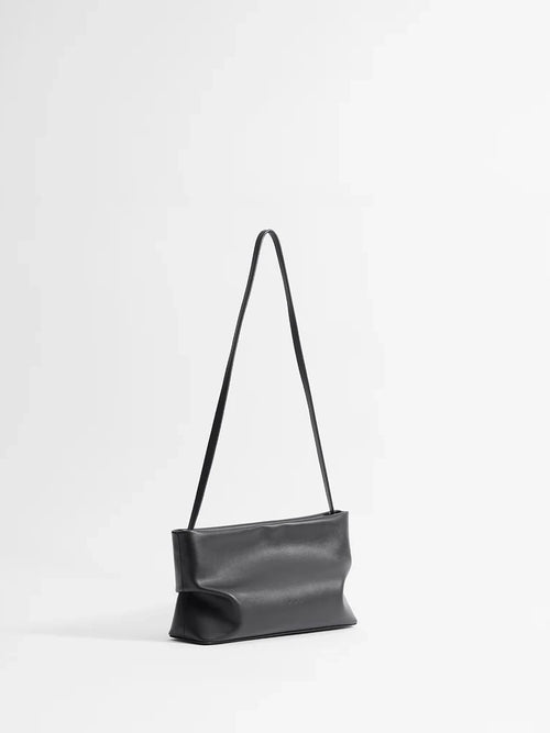Black leather handbag with a strap on a white background