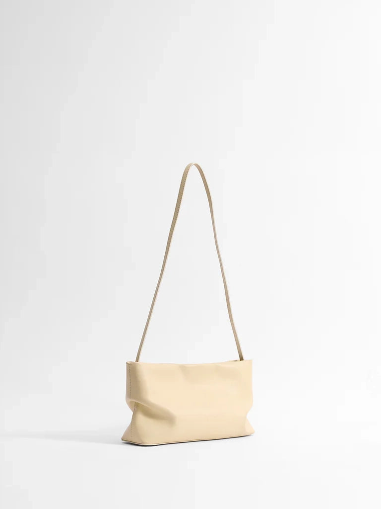 Beige handbag with a strap on a white background