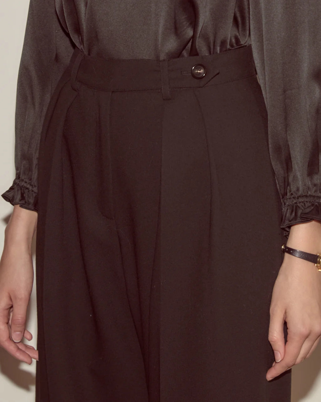 Brown dress with a belt and button detail on a plain background