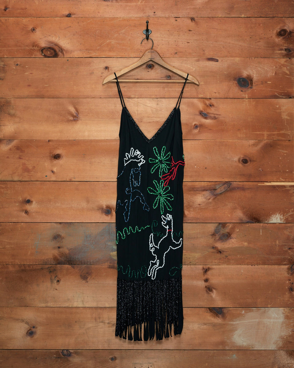 Bode Dream Pony Dress in black silk with multicolor beaded doodle motifs, thin shoulder straps and a fringed hem.