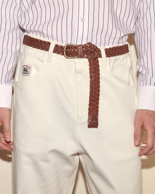 White pants with a brown belt worn by a person, with a focus on the waist area.