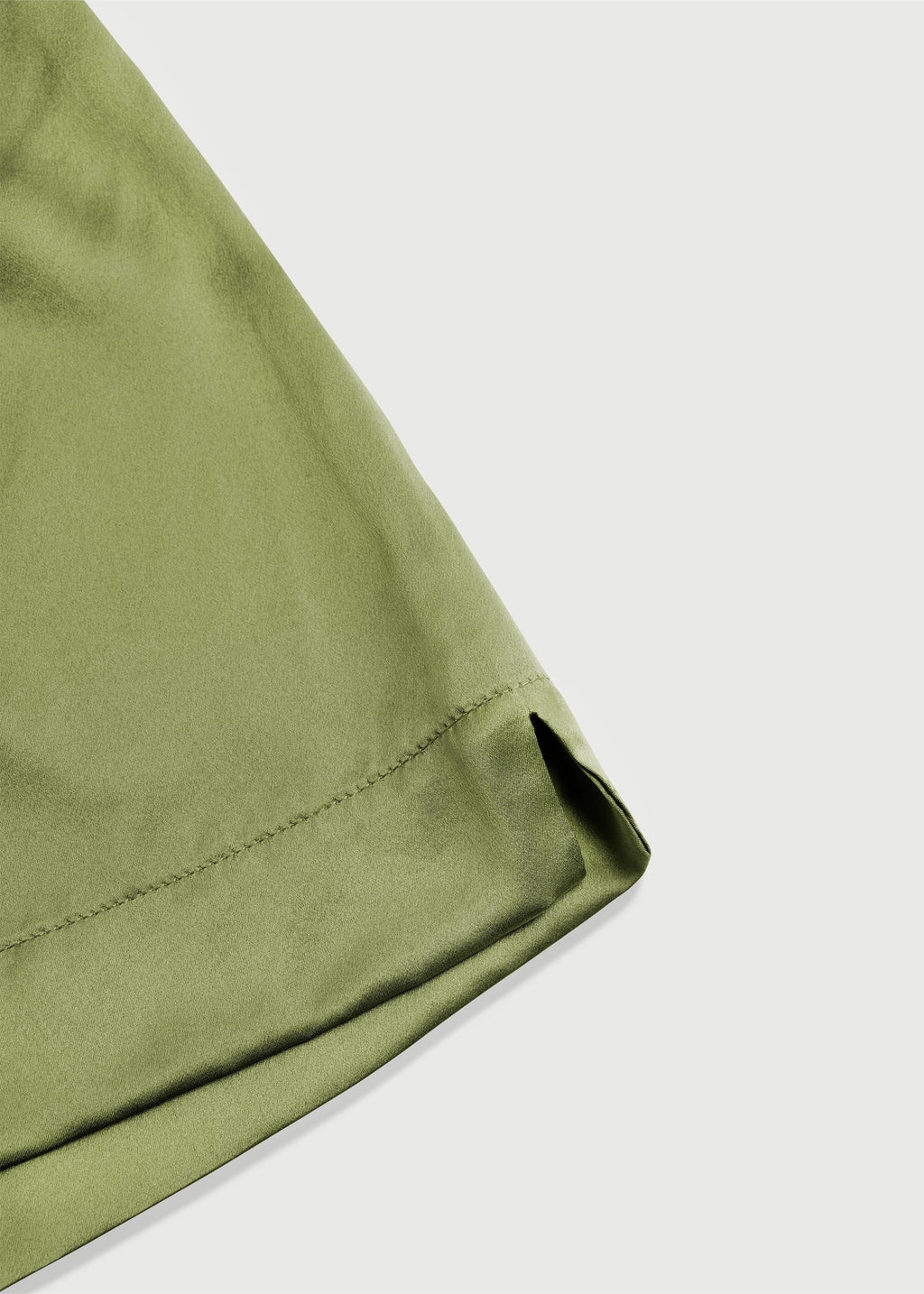 Close-up of a green fabric corner on a light gray background