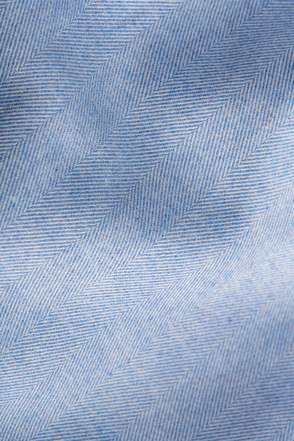 Close-up of blue fabric with a herringbone pattern