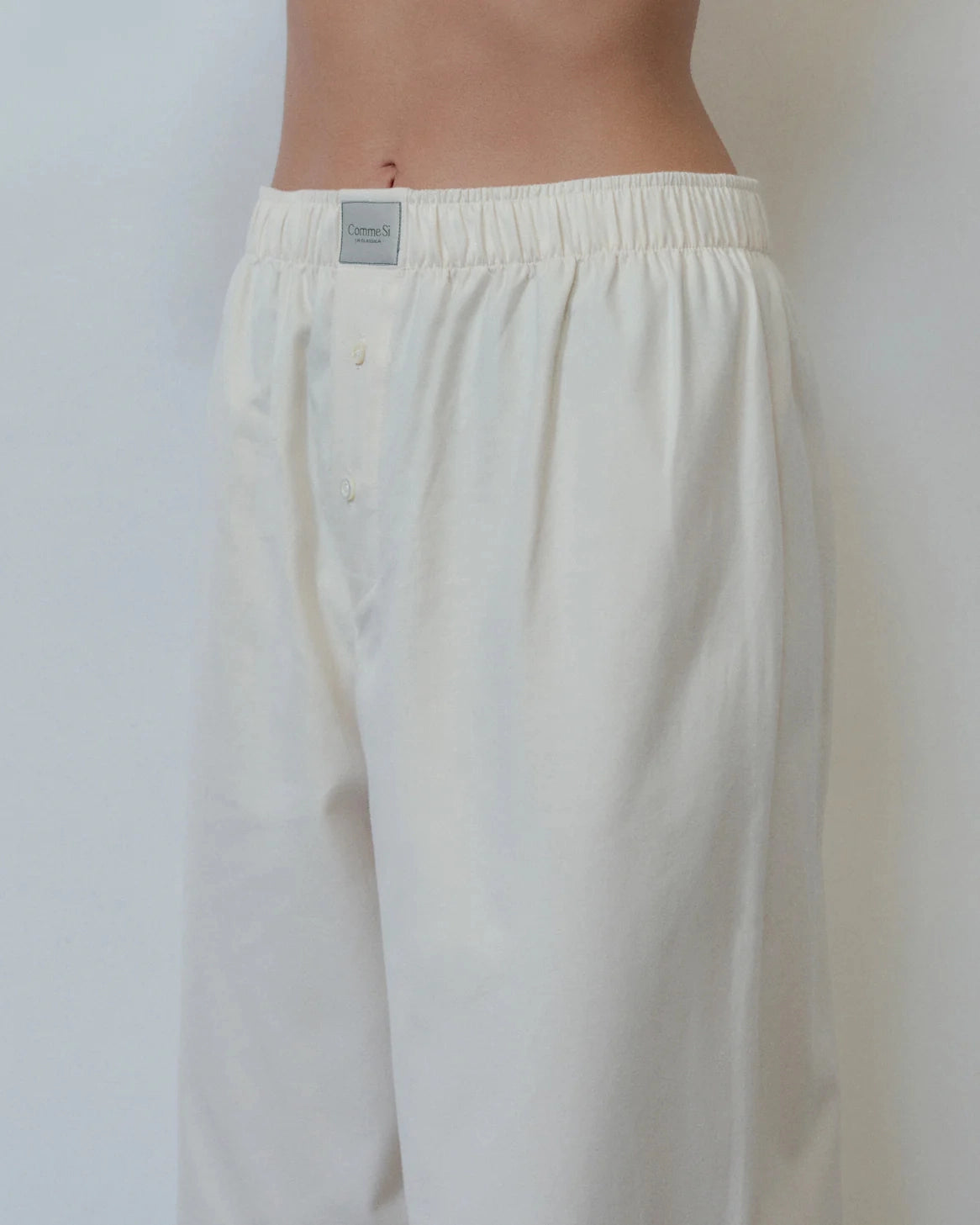 White pants with a visible brand label on a plain background