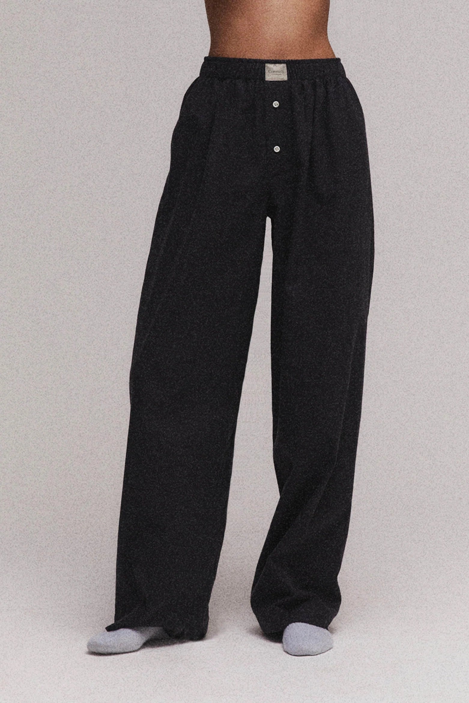 Black pants worn by a person on a plain background