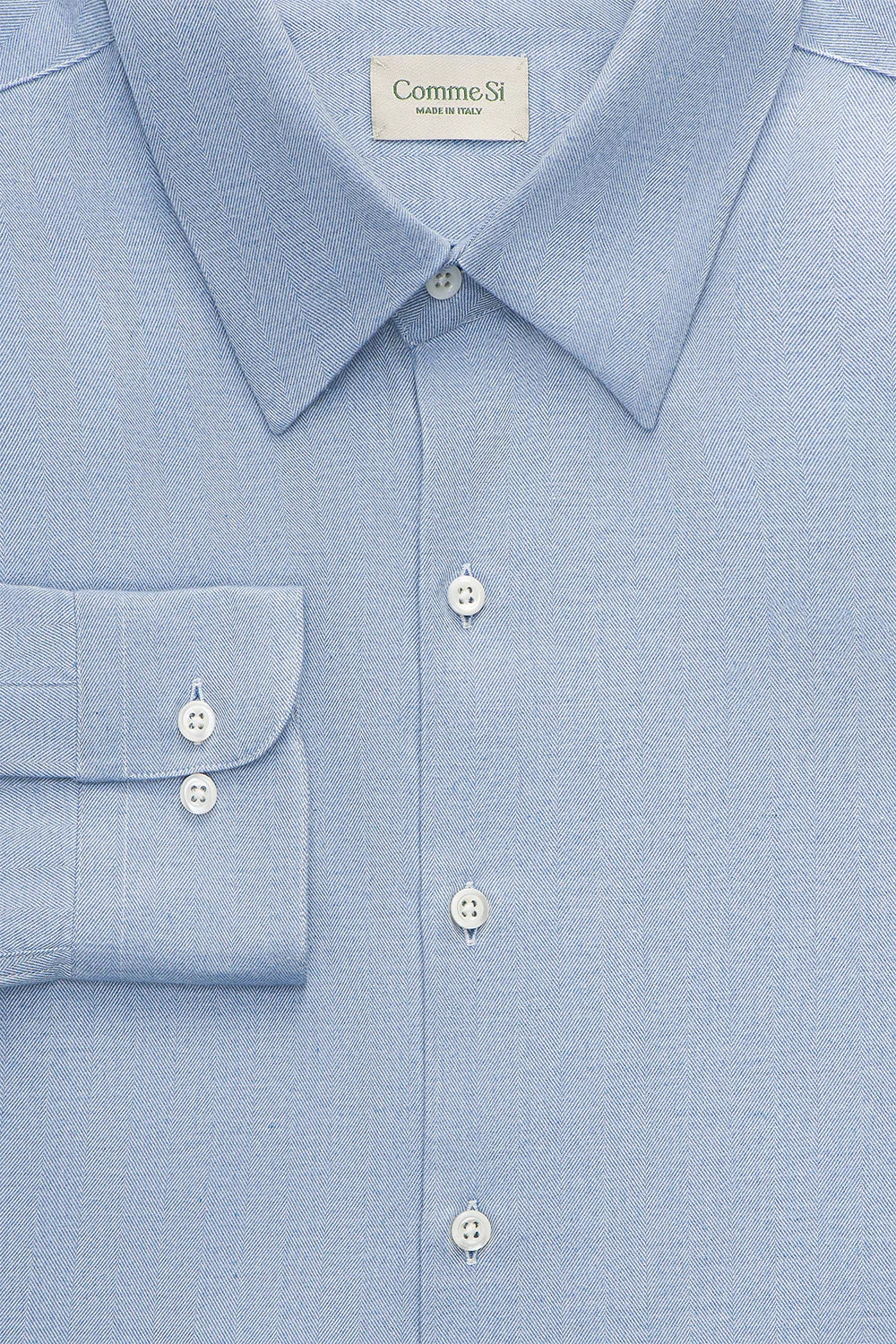 Close-up of a light blue dress shirt with collar and buttons, Comme Si label visible.