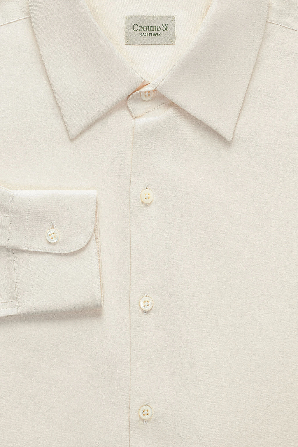 Close-up of a beige shirt with visible Comme Si logo.