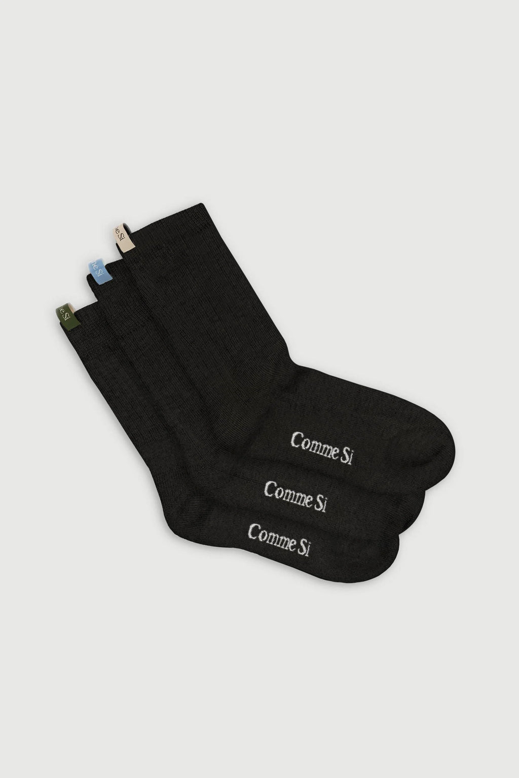 Black socks with 'Comme Si' branding on a light gray background