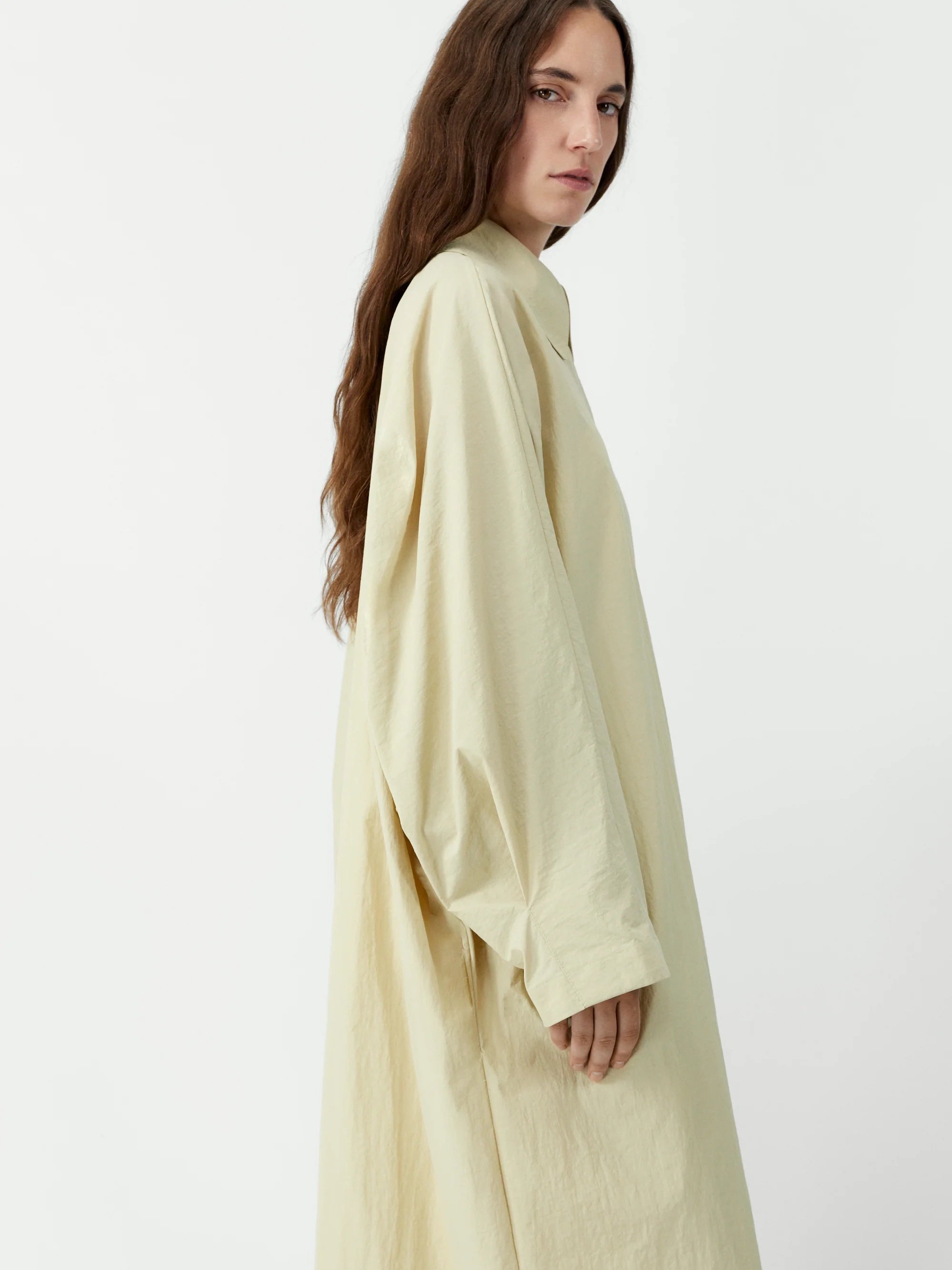 Woman wearing a light green dress against a white background