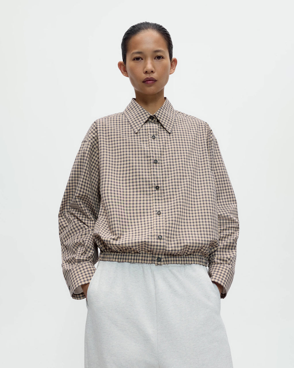 Model wearing CORDERA Checked Bomber Shirt in black and orange with an elasticated waistband, Italian collar and contrast buttons.
