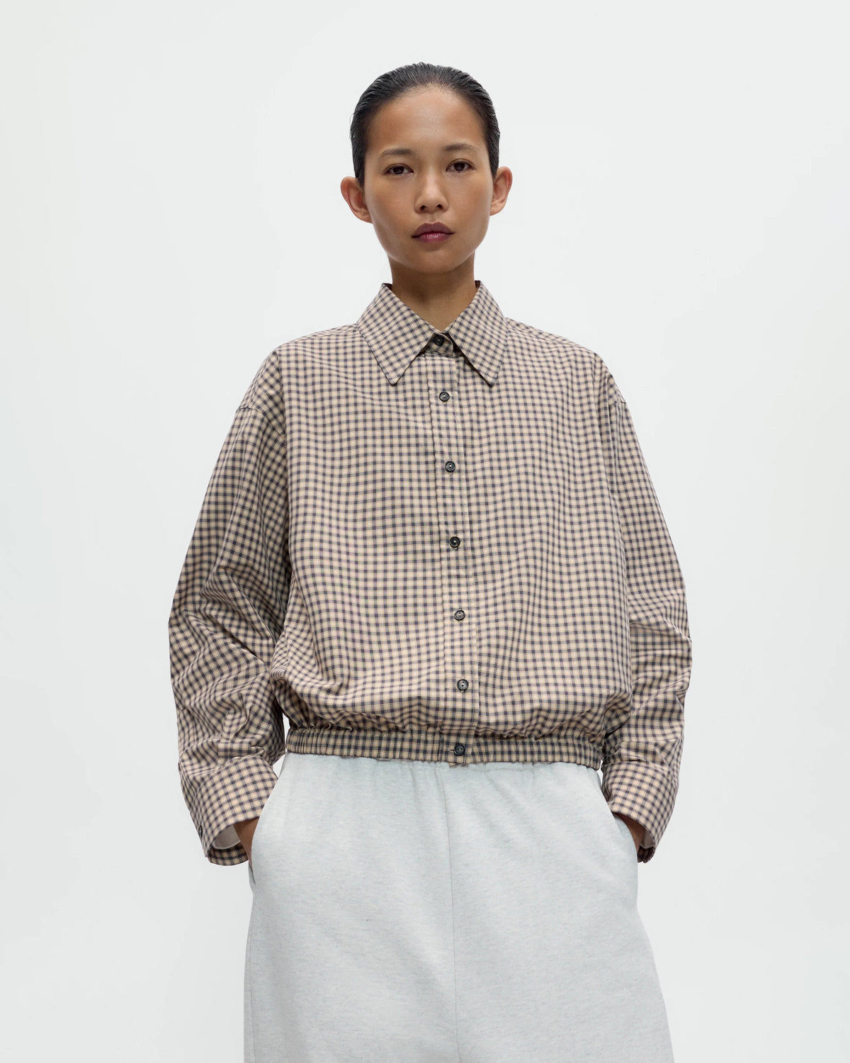 Model wearing CORDERA Checked Bomber Shirt in black and orange with an elasticated waistband, Italian collar and contrast buttons.