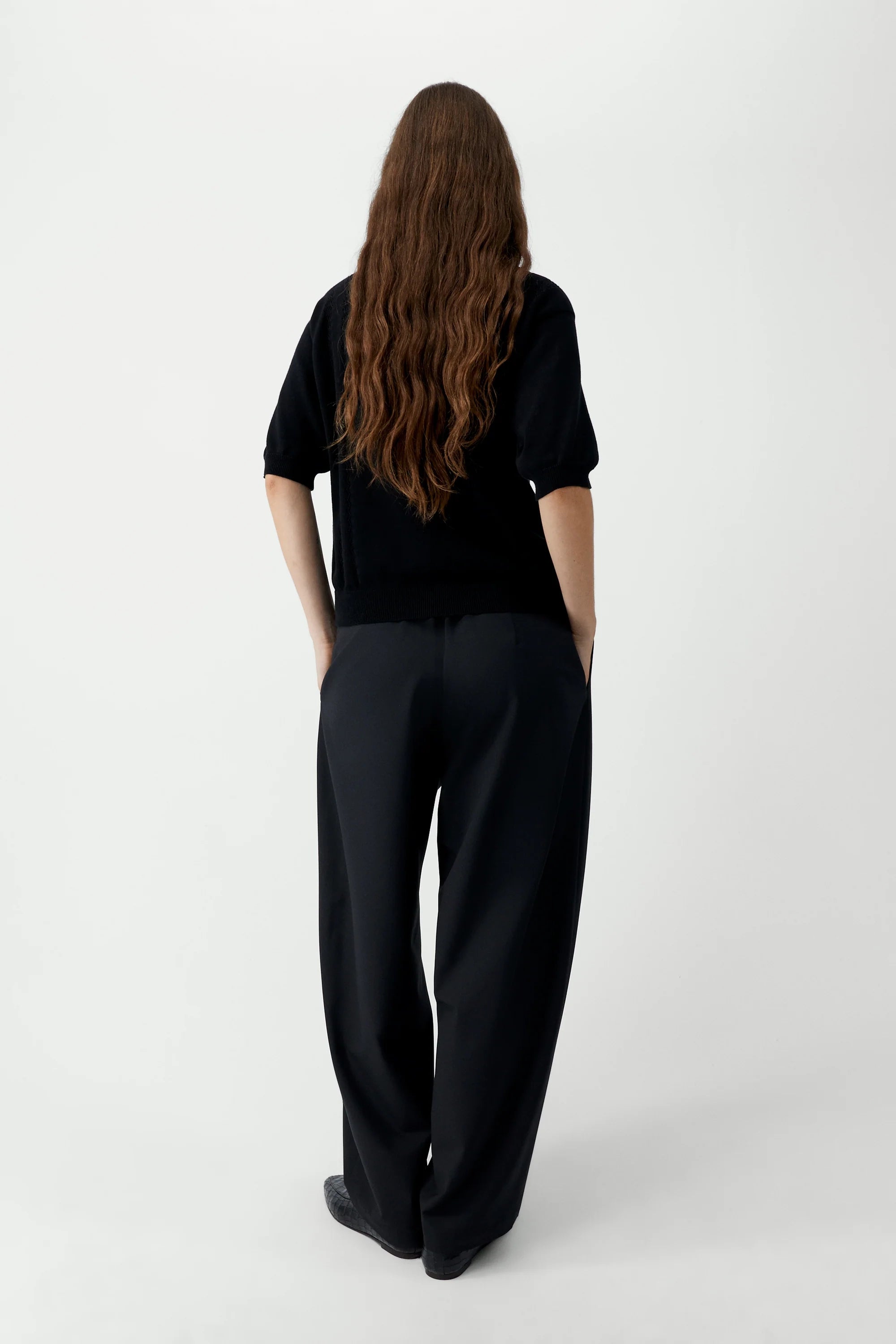Person wearing a black outfit on a white background
