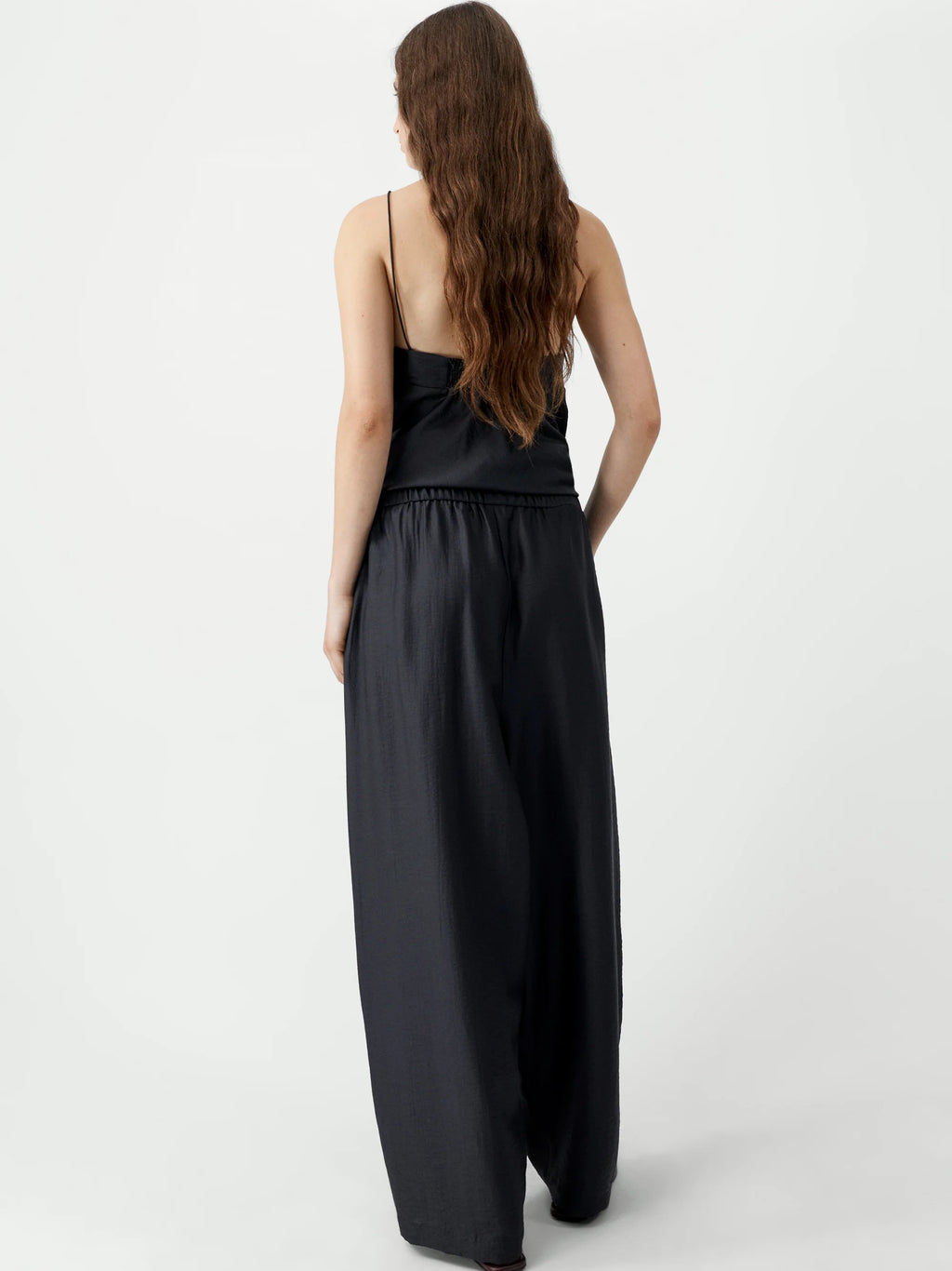 Woman wearing a black jumpsuit on a white background
