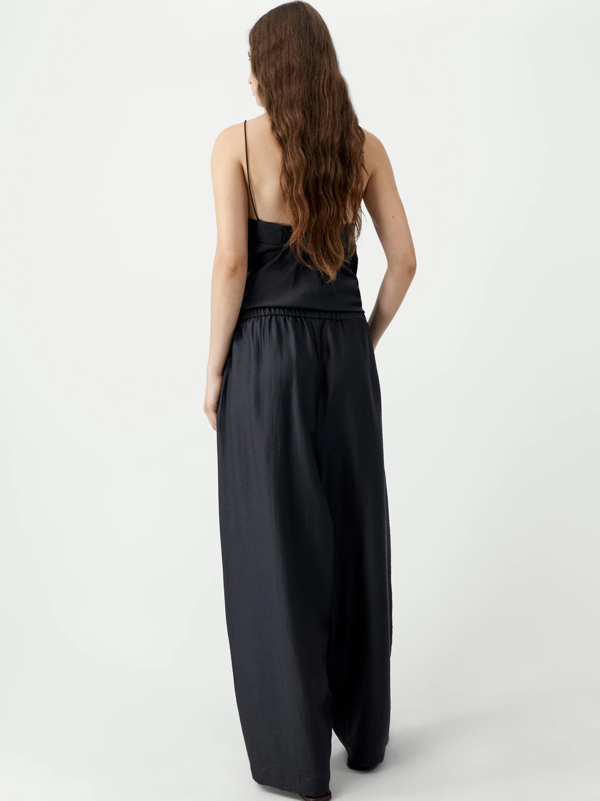 Woman wearing a black jumpsuit on a white background