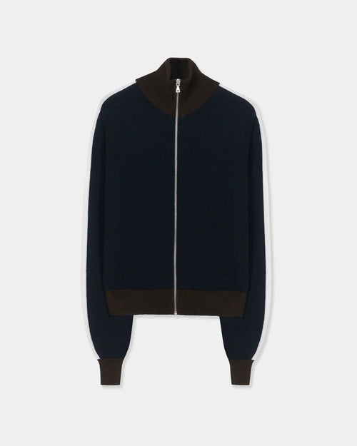 CORDERA Merino Wool Sporty Cardigan in navy with white sleeve stripes, brown ribbed trim and a front zip closure.