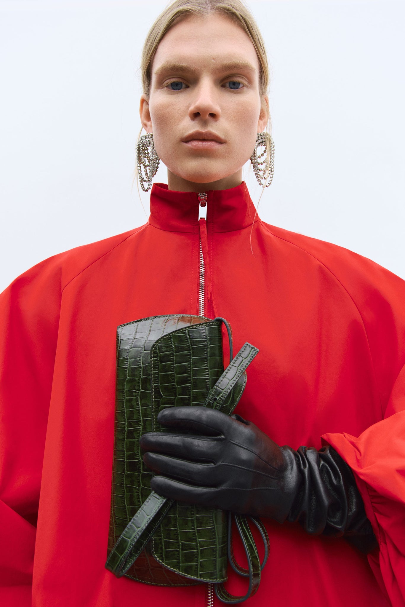 person wearing the red cordera balloon sleeve jacket carrying the swan bag dark green crocodile. spanish clothing designers focusing on sustainability. independent designers. 