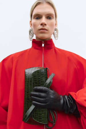 person wearing the red cordera balloon sleeve jacket carrying the swan bag dark green crocodile. spanish clothing designers focusing on sustainability. independent designers. 