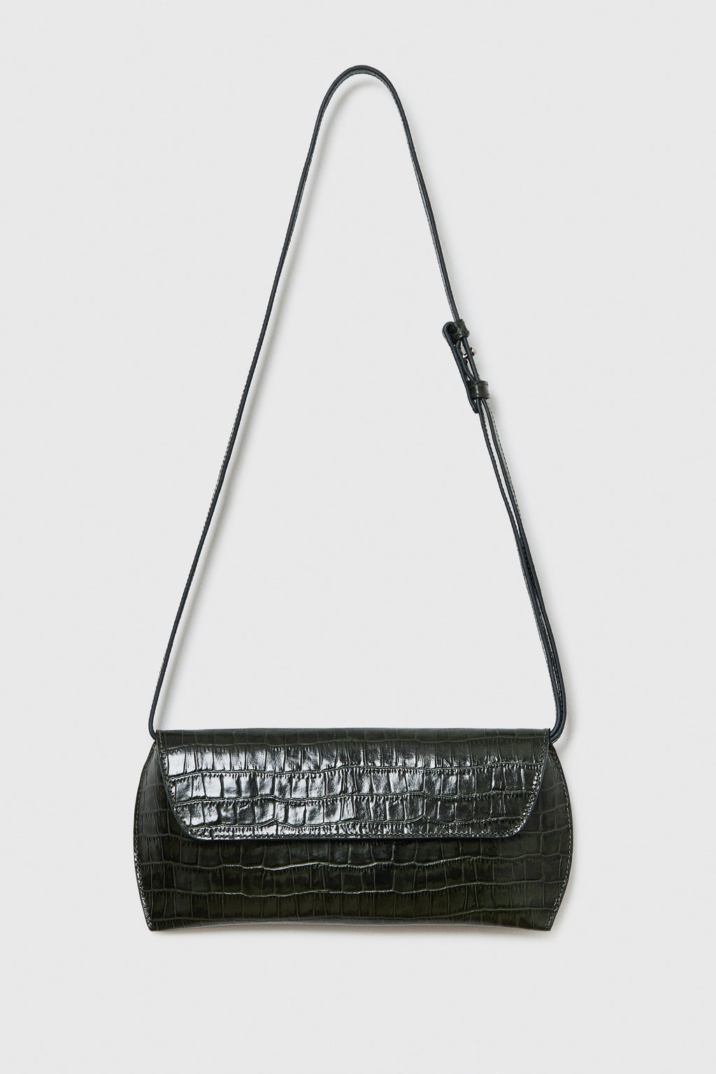 Black crocodile-patterned handbag with a strap on a light gray background