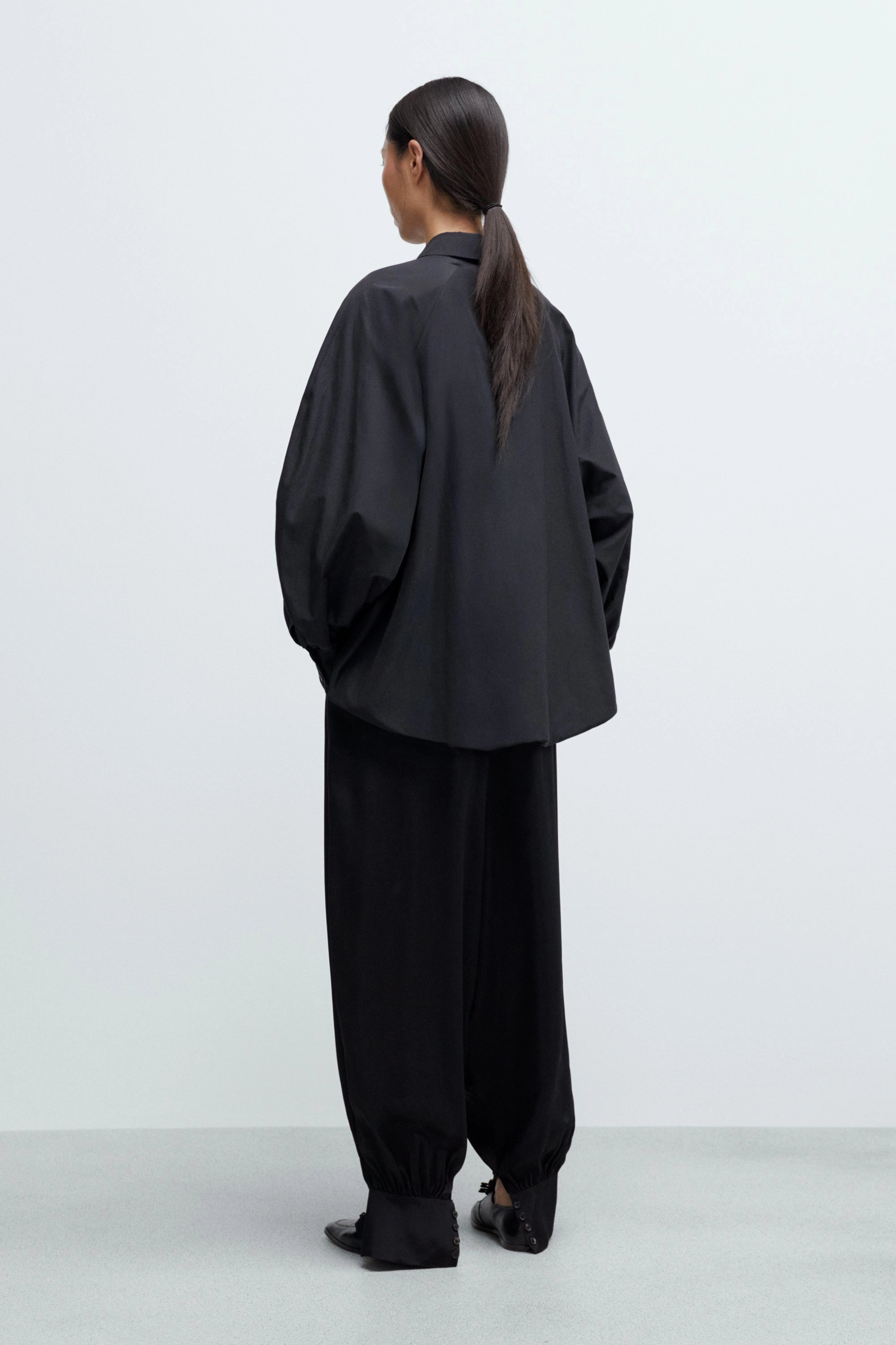 Person wearing a black outfit on a white background