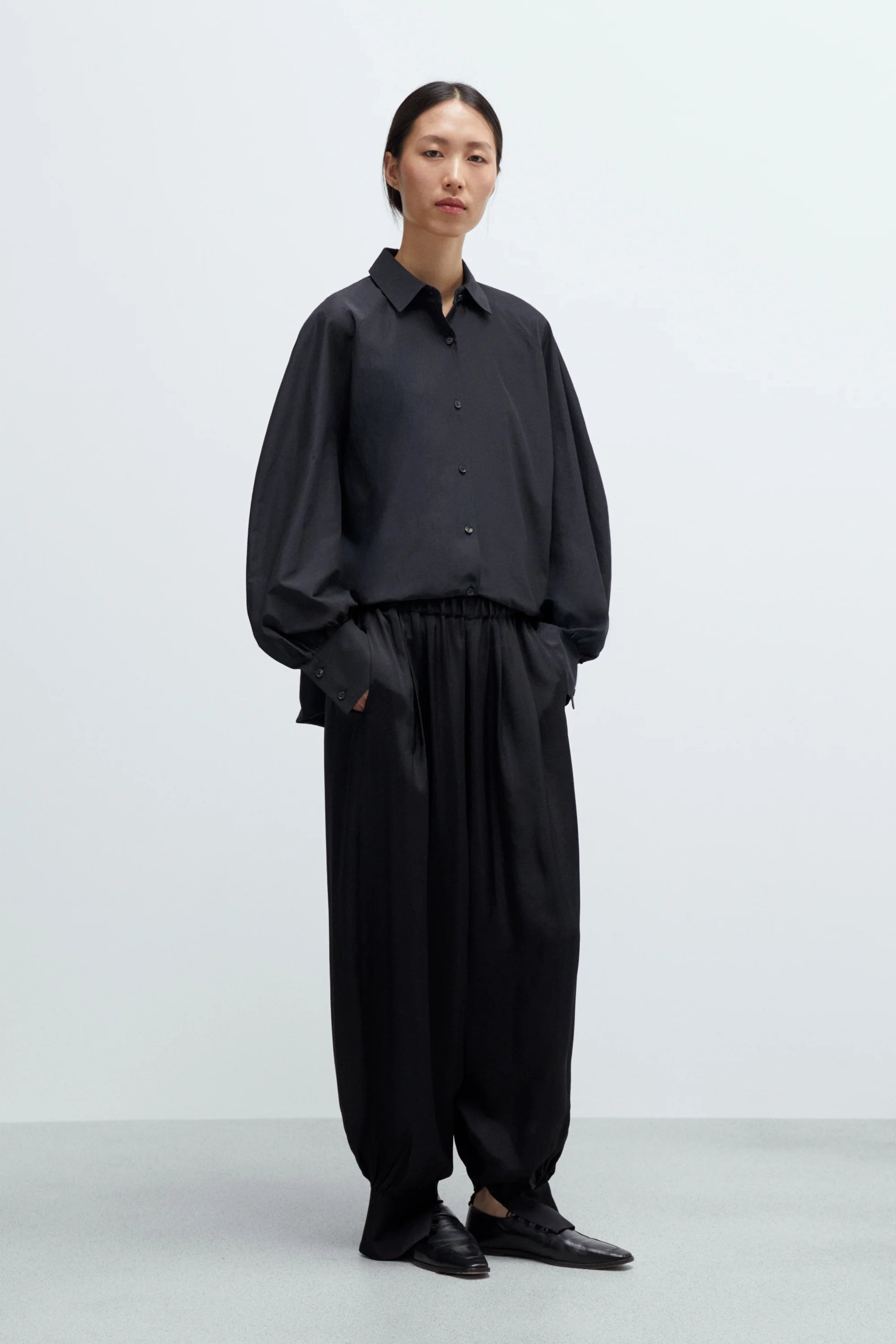 Person wearing a black outfit on a white background